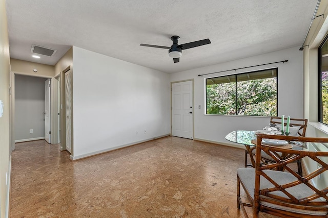 interior space with a textured ceiling and ceiling fan