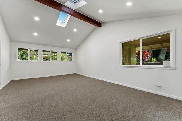 carpeted empty room featuring lofted ceiling with skylight