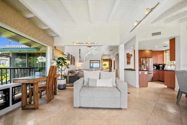 tiled living room with vaulted ceiling with beams, wood ceiling, and sink