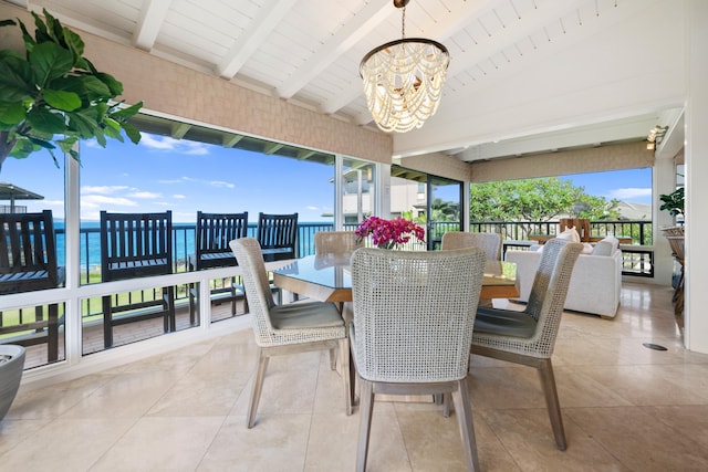 interior space featuring vaulted ceiling with beams, a water view, an inviting chandelier, and a wealth of natural light