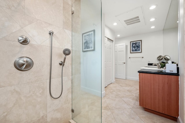 bathroom featuring tile patterned flooring, vanity, and tiled shower