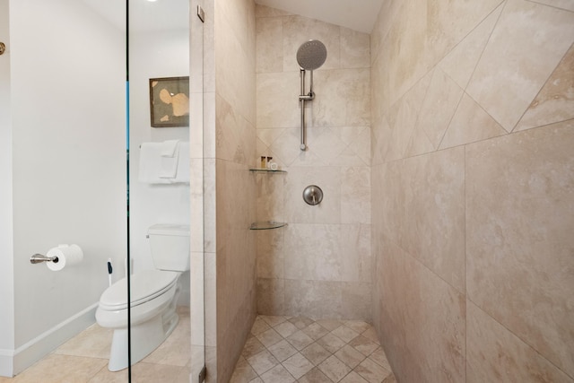 bathroom featuring a tile shower, vaulted ceiling, toilet, and tile patterned floors