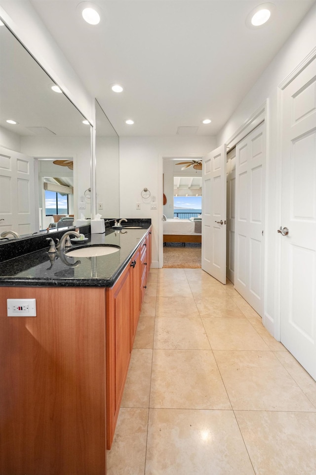 bathroom with tile patterned flooring, vanity, and ceiling fan