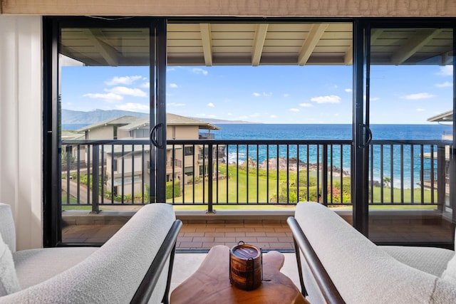 balcony featuring a beach view and a water view