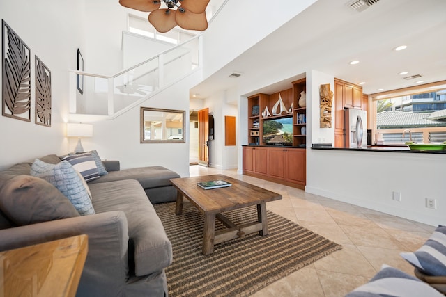 living room with ceiling fan, sink, and light tile patterned floors