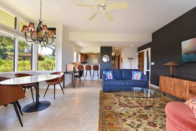 tiled living room with ceiling fan with notable chandelier