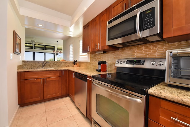 kitchen with light stone counters, light tile flooring, appliances with stainless steel finishes, and sink