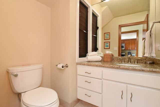 bathroom featuring toilet, large vanity, and tile floors