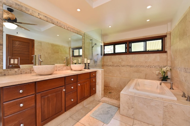 bathroom featuring tile flooring, shower with separate bathtub, vanity, ceiling fan, and tile walls