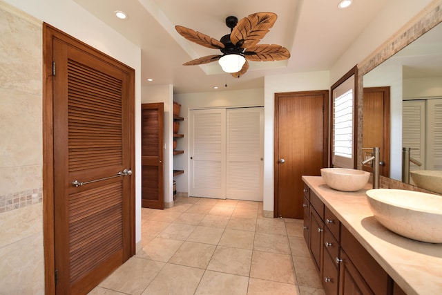 bathroom with ceiling fan, tile flooring, double sink, and vanity with extensive cabinet space