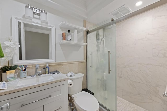 bathroom with a shower with shower door, toilet, and vanity