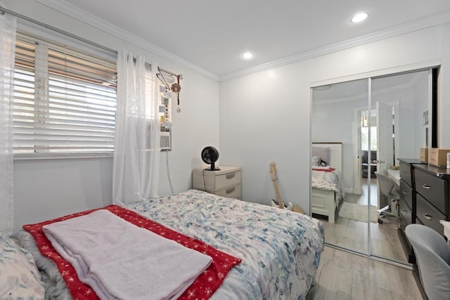 bedroom with a closet, crown molding, and light wood-type flooring