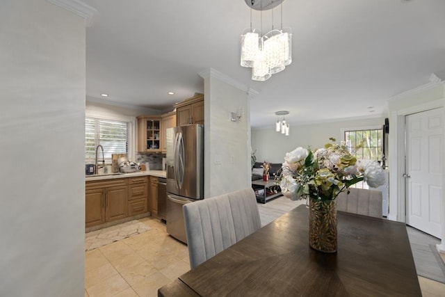 tiled dining room featuring sink, an inviting chandelier, and ornamental molding