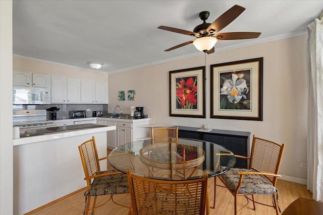 800 S Kihei Rd Unit 504, Kihei, HI 96753 - dining area featuring light wood-style floors, ornamental molding, ceiling fan, and baseboards