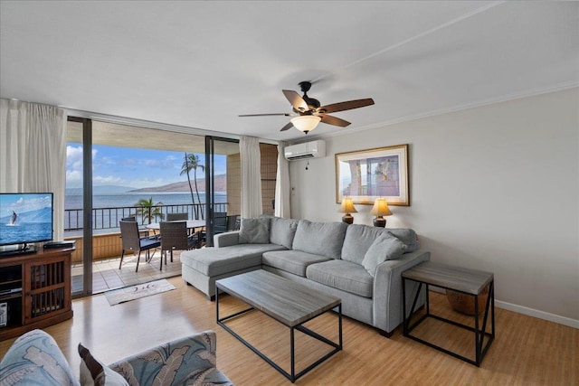 800 S Kihei Rd Unit 504, Kihei, HI 96753 - living room with a water view, light wood-style floors, a wall unit AC, a ceiling fan, and baseboards