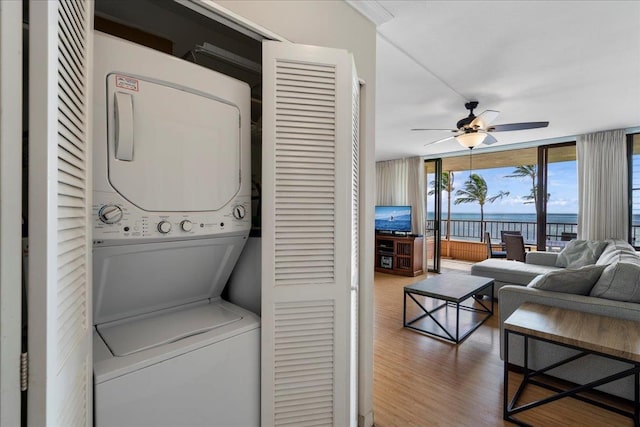 800 S Kihei Rd Unit 504, Kihei, HI 96753 - washroom featuring estacked washer and dryer, wood finished floors, and a ceiling fan