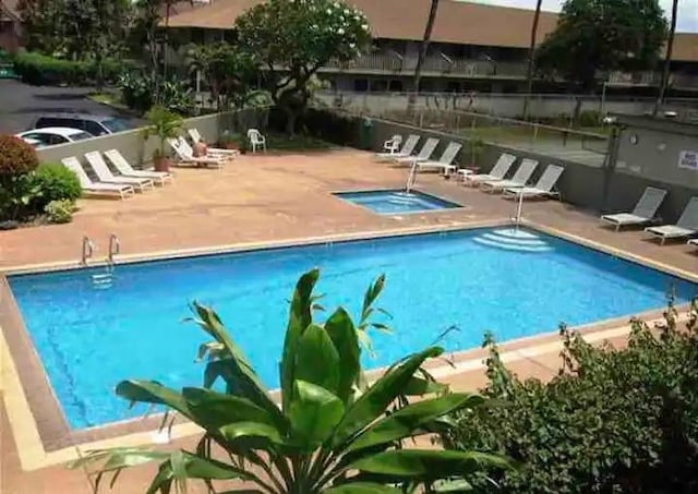 view of swimming pool with a hot tub and a patio