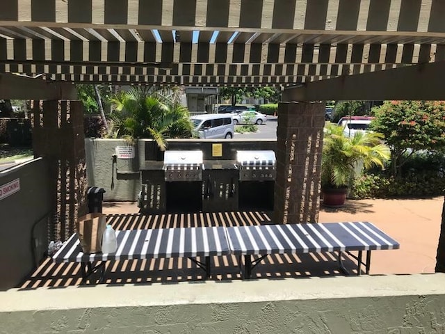 view of terrace featuring exterior kitchen and a pergola