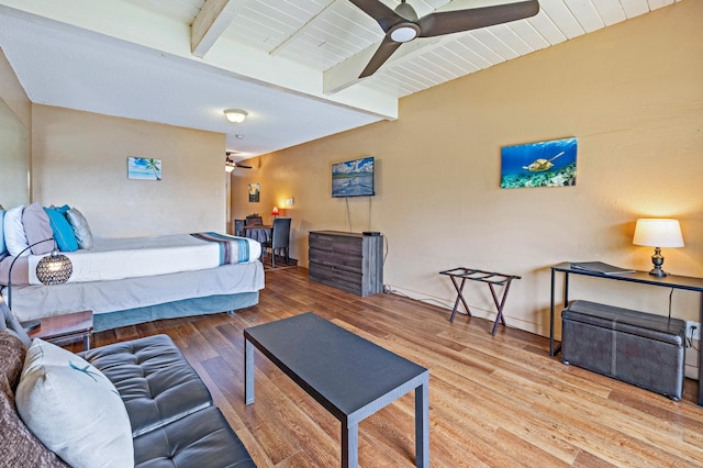 bedroom featuring beamed ceiling, hardwood / wood-style floors, and ceiling fan