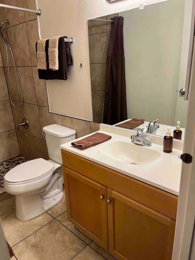 bathroom with walk in shower, vanity, toilet, and tile flooring