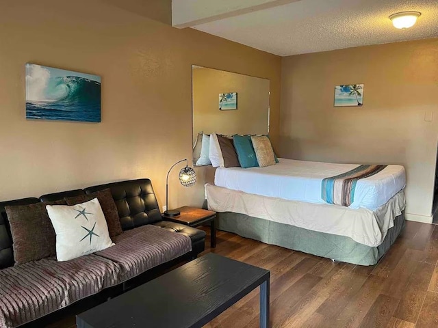 bedroom with dark hardwood / wood-style flooring and a textured ceiling