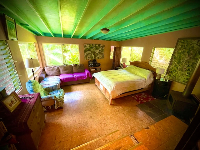 bedroom featuring lofted ceiling and a wood stove