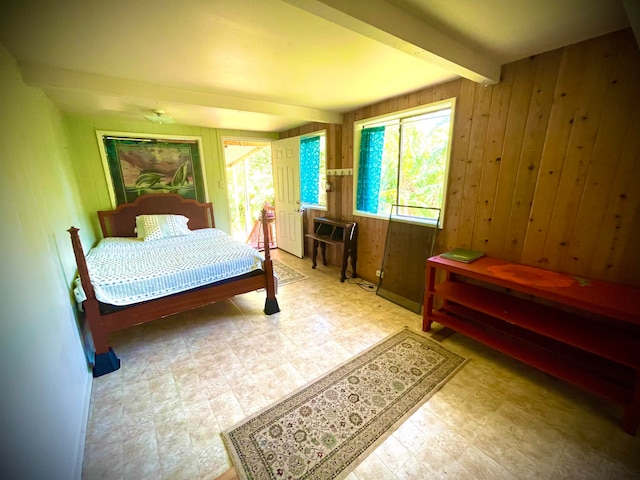 bedroom featuring wooden walls and beamed ceiling