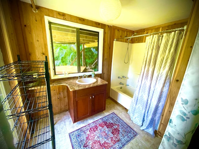 bathroom featuring shower / bath combo, wood walls, and vanity