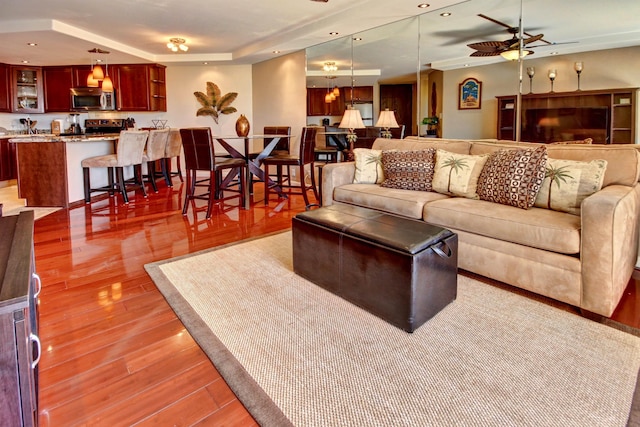 living room with ceiling fan and light hardwood / wood-style floors