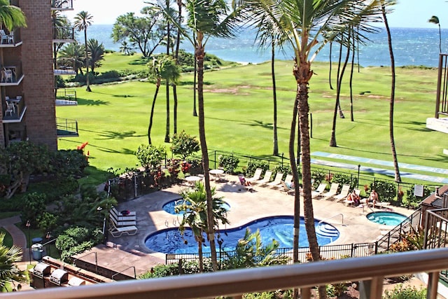 view of pool with a lawn, a patio area, and a water view