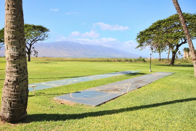 view of property's community featuring a mountain view, a rural view, and a yard