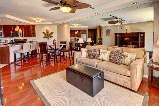 living room featuring hardwood / wood-style flooring and ceiling fan