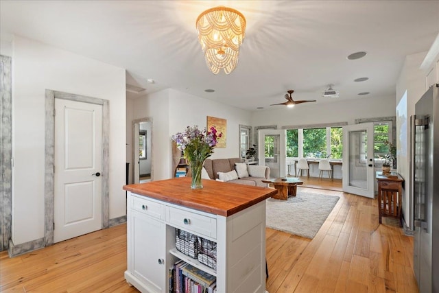 kitchen featuring butcher block countertops, freestanding refrigerator, white cabinets, and light wood-style floors