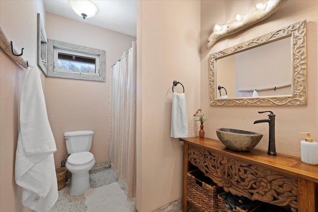 bathroom with curtained shower, vanity, and toilet