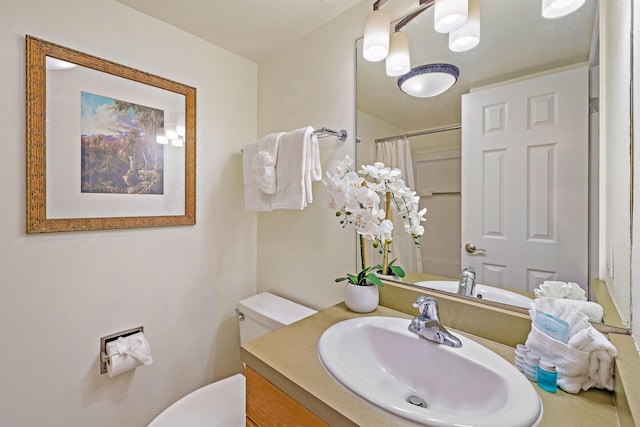 bathroom featuring curtained shower, vanity, and toilet