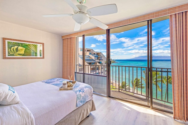 bedroom with ceiling fan, light hardwood / wood-style flooring, expansive windows, access to outside, and a water view