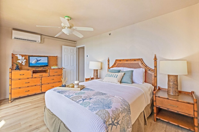 bedroom featuring ceiling fan, an AC wall unit, and light hardwood / wood-style flooring