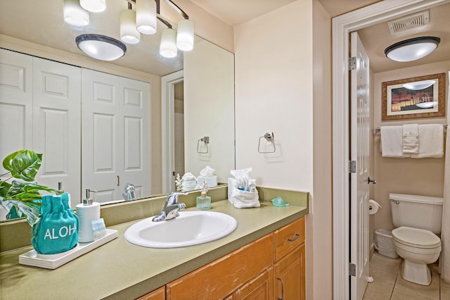 bathroom with tile patterned flooring, vanity, and toilet