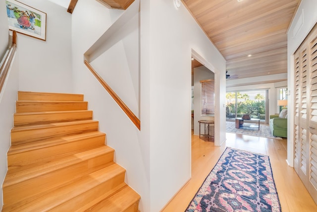 stairway featuring hardwood / wood-style flooring and wooden ceiling