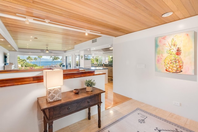 interior space with track lighting, light tile patterned floors, and wooden ceiling