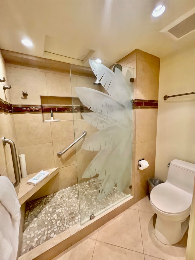 bathroom featuring tile patterned flooring, tile walls, toilet, and walk in shower