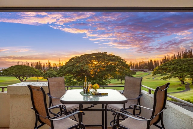 patio terrace at dusk featuring a lawn