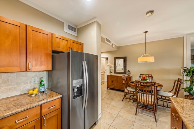 kitchen with light stone countertops, decorative backsplash, hanging light fixtures, and stainless steel fridge with ice dispenser