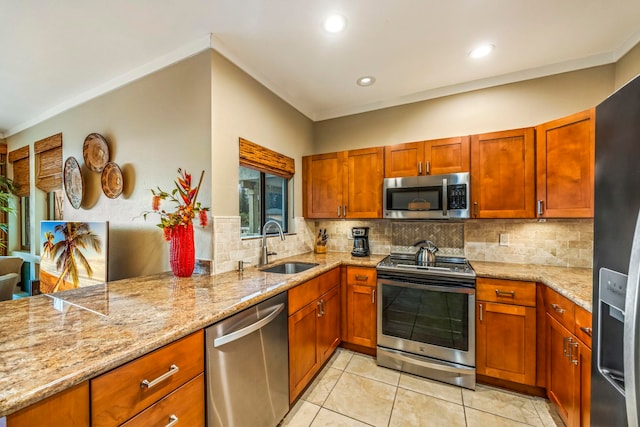 kitchen featuring sink, kitchen peninsula, stainless steel appliances, backsplash, and light stone countertops