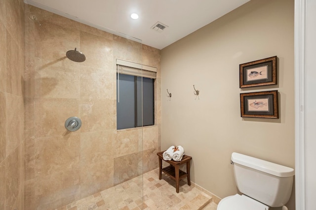 bathroom featuring a tile shower and toilet