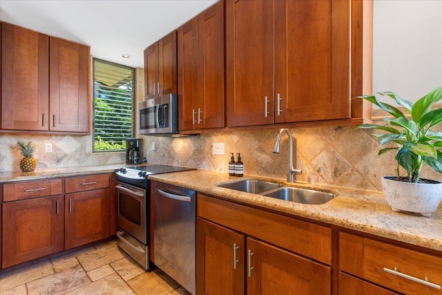 kitchen with backsplash, sink, stainless steel appliances, and light stone countertops