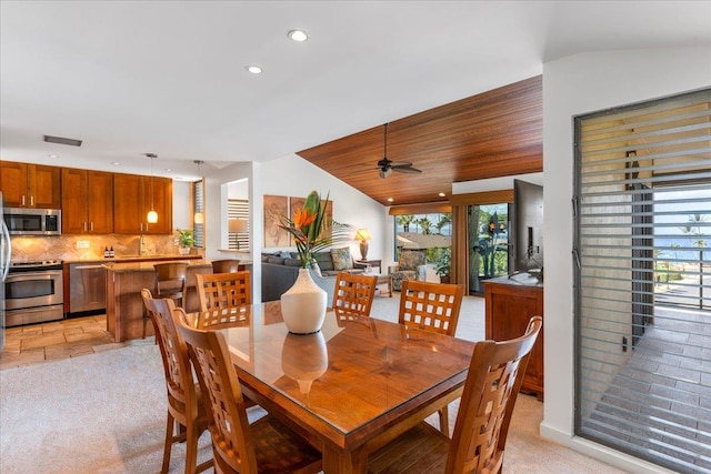 carpeted dining space featuring wood ceiling, lofted ceiling, and ceiling fan