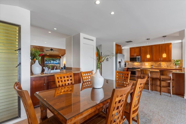 carpeted dining space featuring ceiling fan