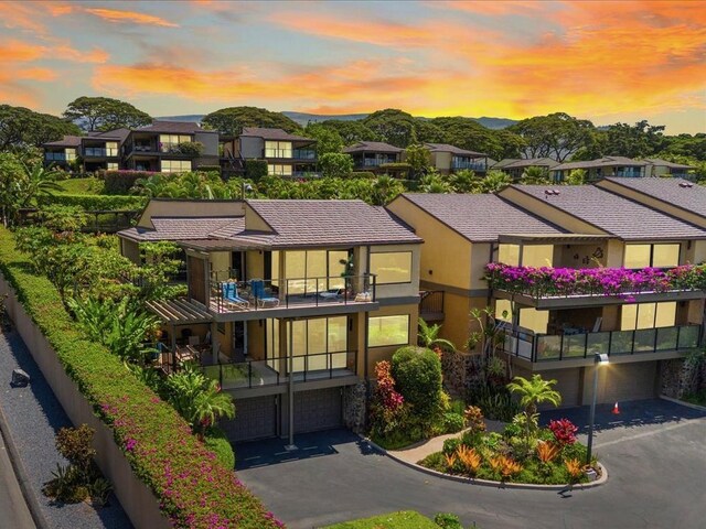3600 Wailea Alanui Dr Unit 708, Kihei, HI 96753 - view of front of house with a balcony, a garage, asphalt driveway, stucco siding, and a residential view