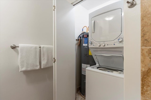 laundry area featuring stacked washer and dryer and electric water heater